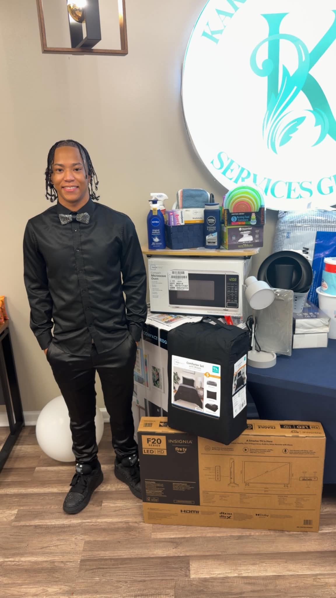 College-bound student with dorm room essentials, television, microwave, bedding, and supplies
